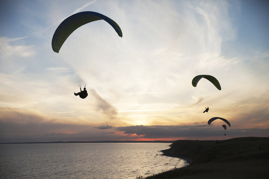 Paragliders at sunset