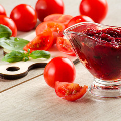Barbecue sauce in a gravy boat, tomatoes and Basil