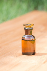 little brown bottle on booden board and grass