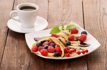 Cup of coffee and pancakes with berries