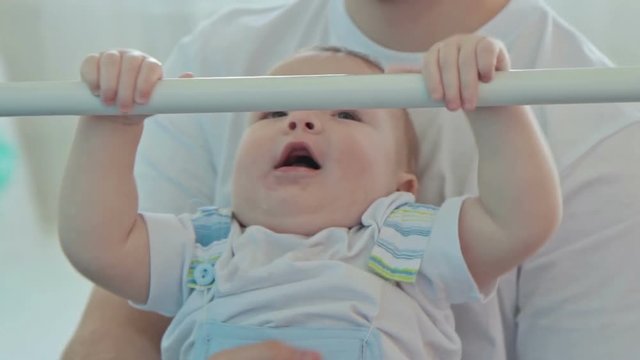 Father helping baby hanging