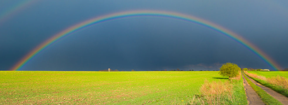 Regenbogen Regenb&ouml;gen nach schwerem Unwetter und Sonnenschein von hinten