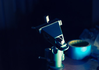 Small DIY hobby clamp with detail in dark room, backlit, toned image