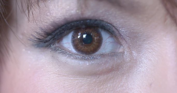 Big close up of Asian woman's right eye with contact lens visible as she looks at the camera and looks around. Recorded in 4K at 60fps.