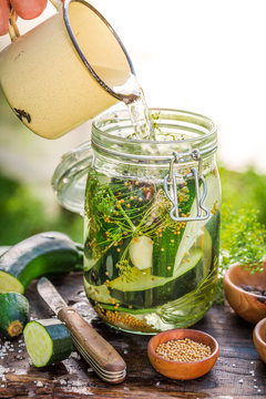 Pouring water into jar with zucchini and spices
