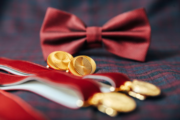 Men's accessories - bow tie, wedding rings, cufflinks on textile background.