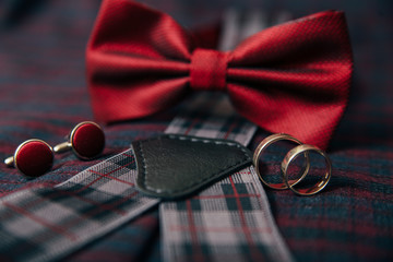 Men's accessories - bow tie, wedding rings, cufflinks on textile background.