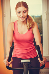 Woman working out on exercise bike. Fitness.