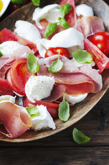 Italian salad caprese with ham, basil and mozzarella