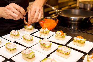 cook put caviar on delicious gourmet canape starters