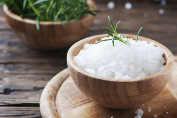 Sea salt and fresh rosemary on the wooden table
