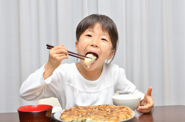ギョウザを美味しそうに食べる女の子
