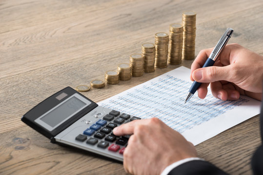 Close-up Of A Businessman Analyzing Financial Report