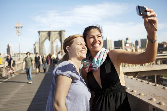 Two female tourists taking selfie on Brooklyn Bridge