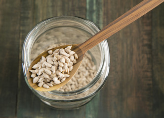 Sunflower seeds in a glass jar on wooden background