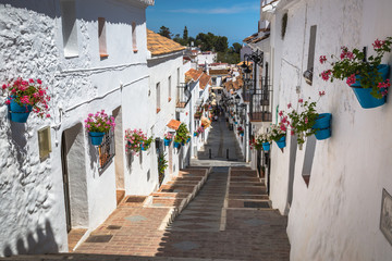 Street with flowers in the Mijas town, Spain - obrazy, fototapety, plakaty