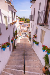 Fototapeta na wymiar Picturesque street of Mijas with flower pots in facades. Andalus