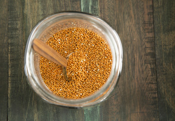 Millet in a glass jar on wooden background