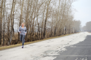 Runner woman running on road in beautiful nature. Jogging traini