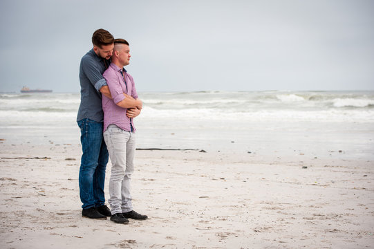 Gay Men Embracing On A Beach