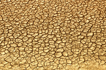 Details of a sunny dried cracked earth soil ground background. Mosaic pattern of sunny dried earth soil.