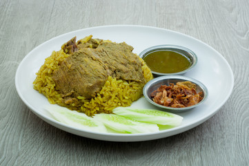 Beef Biryani white plate on a wooden floor.