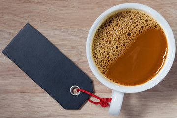 coffee cup with price tag on wood background