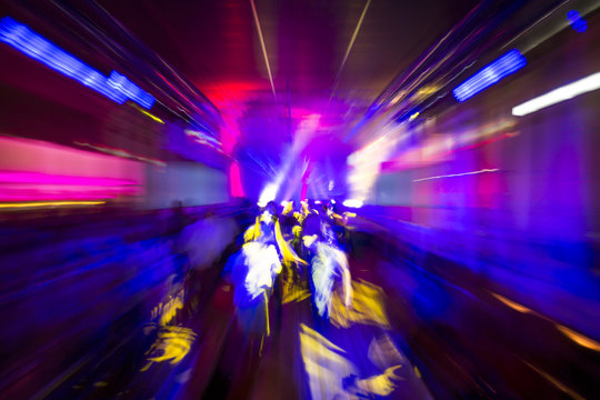 Colourful night club party lights in motion blur, abstract background design, people dancing drunk or on drugs