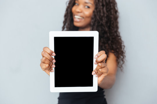 Smiling afro american woman showing blank tablet computer