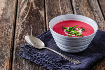 Rote-Bete-Suppe in weißer Schale auf Holz