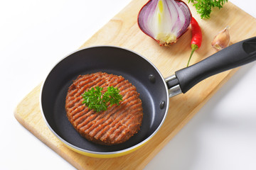 Beef burger patty in pan