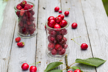 Glasses full freshly picked cherries raspberries