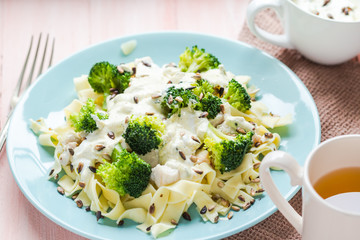 Pasta dish broccoli sauce sunflower seeds