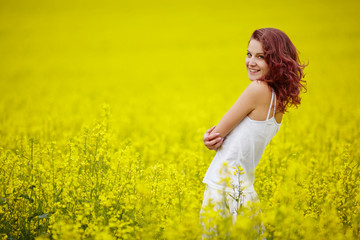 Naklejka na ściany i meble young beautiful girl in yellow field