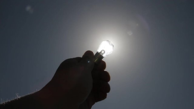 silhouette hand with electric lamp light instead of electricity from the sun