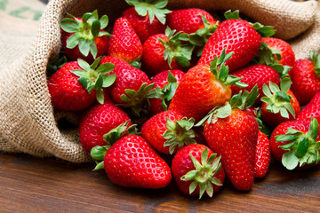 fresh strawberry in burlap sack on wood - 109299944
