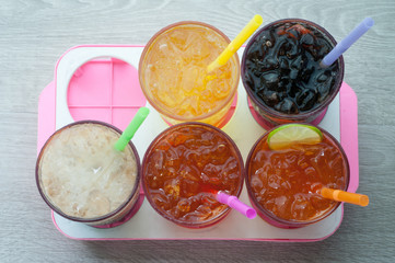 Four glasses of cold, fresh, homemade sodas with ice and drinkin