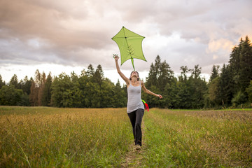 Young woman flying a green kite