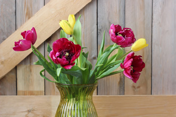 Bouquet of tulips on the background of boards.