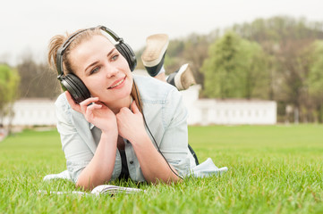 Young happy girl with headphones listening music