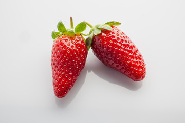 Two strawberries on white background view from above