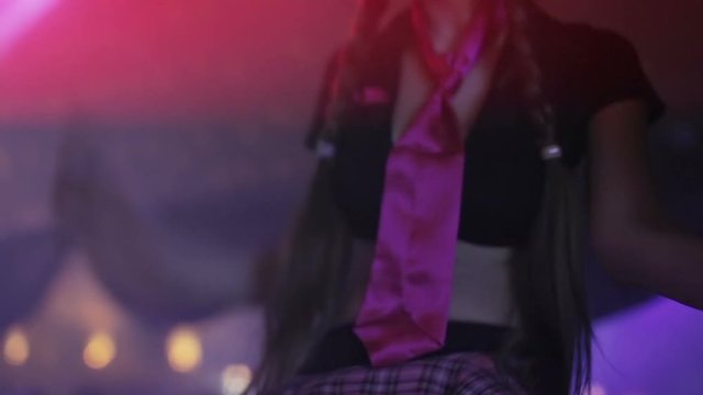 Female in plaid skirt and pink tie dancing gogo