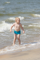 the little boy frolics at the sea