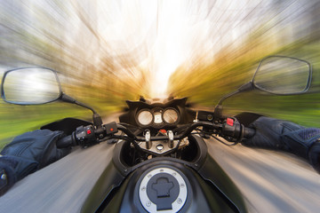 Hands on the steering wheel while driving a motorcycle at speed.