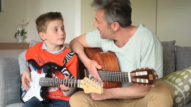 Daddy with son playing the guitar