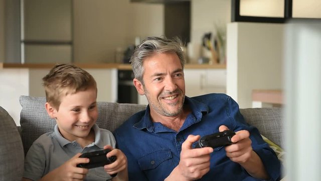Father and son playing video game on tv