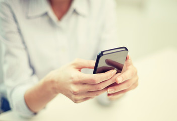 close up of woman texting on smartphone at office