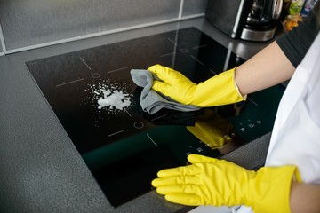 woman's hands cleaning induction cooker
