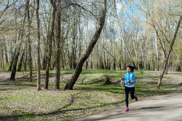 Obraz premium Young woman in black tights running around the Park