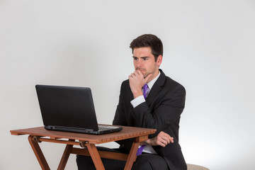 Business man is sitting thoughtfully on a laptop